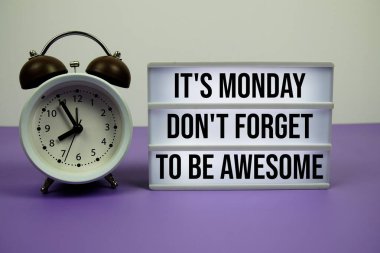 Bugün Pazartesi. Mor zemin üzerinde çalar saat olan ışık kutusunda muhteşem olmayı unutmayın.