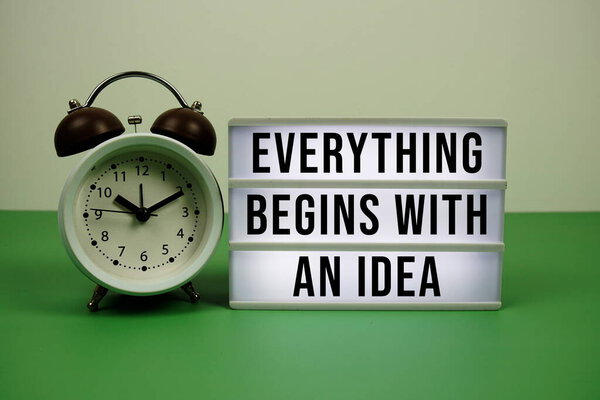 Все начинается с текста идеи на лампочке с будильником на зеленом фоне