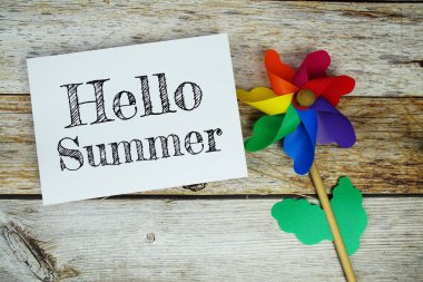 Merhaba. Tahta zemin üzerinde renkli fırıldak manzaralı kağıt kart üzerine yaz metni.