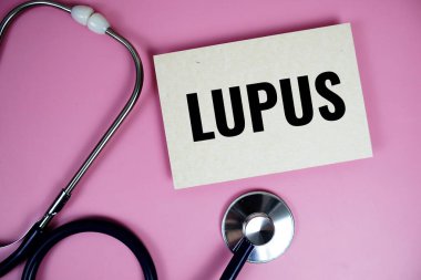 Pembe arka planda steteskoplu Lupus metni, sağlıklı ve sağlıklı olma kavramı