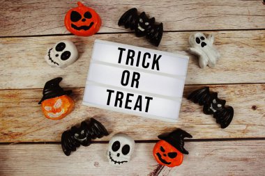 Cadılar Bayramı elementi ahşap arka planda olan ışık kutusuyla şaka mı şeker mi metni