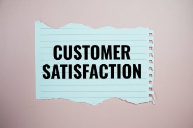 Pembe arkaplanda kağıt üzerine yazılan müşteri memnuniyeti metni yırtılmış üst görünüm