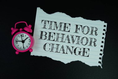 Davranış Zamanı Siyah zemin üzerinde alarmlı saat ile metni motive edici ve ilham verici olarak değiştir