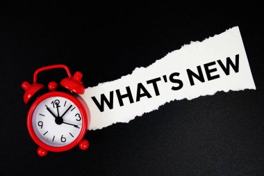 Alarm saati ile yırtılmış kağıttaki yeni metin nedir? Siyah arkaplanda üst görünüm