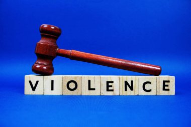 Şiddet alfabesi harfleri tahta bloklar alfabe harfleri ve mavi arka planda Gavel.