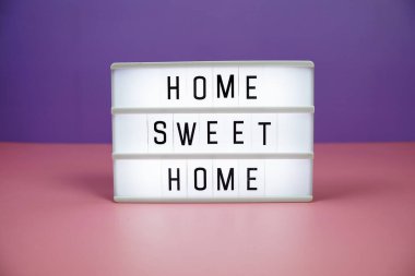 Pembe ve mor arkaplanda LED Işıkkutusu üzerine Home Sweet Home antetli metin