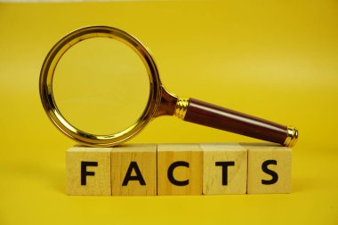 Tahta bloklar, alfabe harfleri ve sarı arkaplanda büyüteç.