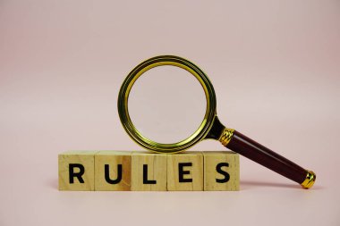 Ahşap blok alfabe harfleri ve pembe arka planda büyüteç içeren kurallar