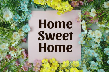 Çiçek çerçeve dekorasyonlu Home Sweet Home metni mavi arkaplanda üst görünüm