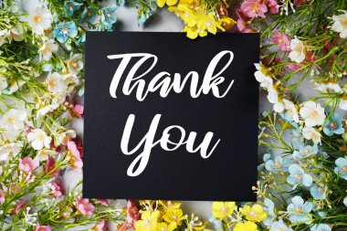 Mavi arkaplanda çiçek çerçeve dekorasyonlu Teşekkür metni