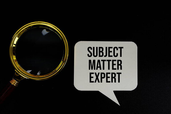 Тема Matter Expert text on speech bluble with magnifying glass top view on black background