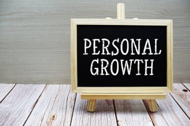 Tahta üzerine ahşap arka planda sehpası olan kişisel büyüme metni