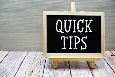 Tahtaya yazılmış ahşap arka planda resim sehpası olan hızlı ipuçları metni