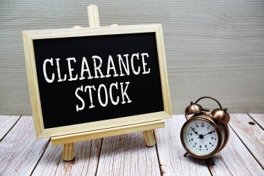 Tahtaya yazılan ve ahşap zemin üzerinde alarm saati olan Geçiş Borsası metni