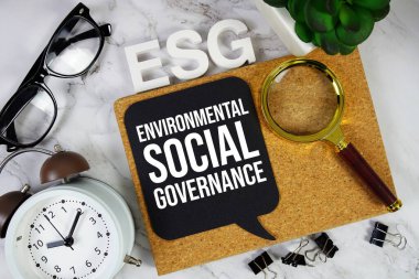 ESG - Alarm saati ve büyüteç ile Çevre Sosyal Yönetimi kısaltması, iş konsepti geçmişi