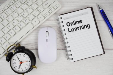 Not defterinde klavye ve tahta arka planda optik fare ile çevrimiçi öğrenme metni