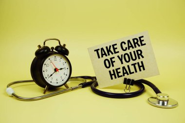 Konuşma balonunda alarm saati ve sarı arka planda steteskop ile sağIıklı konsept üzerine sağIıklı metinlerinize dikkat edin.