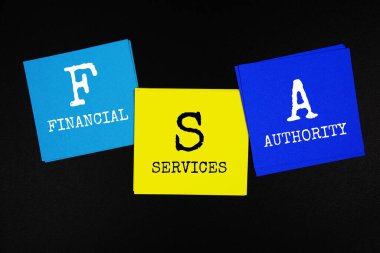 FSA - Financial Services Authority acronym text on sticky note on black background clipart