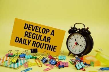 Kağıt üzerinde kağıttan bir günlük rutin metin ve sarı arkaplanda alarm saati oluştur