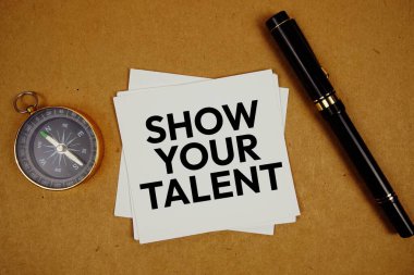 Show Your Talent text on sticky note with compass and pen on paper craft background clipart