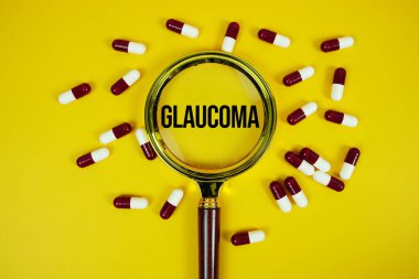 Sarı arkaplan üzerinde glaukoma metni olan ilaç kapsülü ve büyüteç