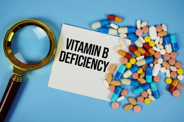 B vitamini eksikliği metni mavi zemin üzerinde ilaç ve büyüteç içeren yapışkan not kağıdı üzerinde