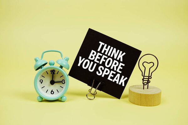 Подумайте, прежде чем говорить текстовое сообщение на бумажной карточке с будильником хлопок на желтом фоне