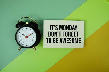 Bugün Pazartesi. Kağıt üzerinde yeşil ve sarı geometrik zemin üzerinde alarm saati olan harika olmayı unutmayın.