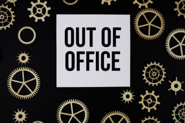 Out of Office text on paper and gear on black background clipart