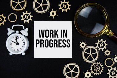 Siyah zemin üzerinde büyüteç ve alarm saati olan yapışkan notla ilgili çalışma süreci metni