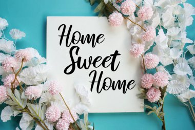 Çiçek çerçeve dekorasyonlu Home Sweet Home metni mavi arkaplanda üst görünüm