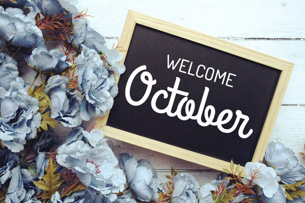 Приветственный октябрь текст с цветами рамка украшения вид сверху на деревянном фоне,