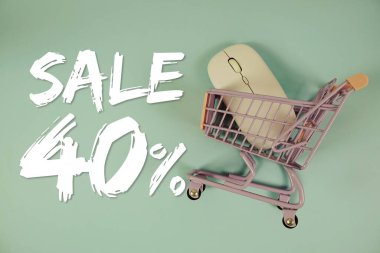 % 40 indirimli indirimli alışveriş, alışveriş arabası ve mavi arka planda optik fare.