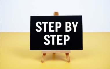 Kağıt kartın üzerine yazılan ve sarı arkaplanda duran adım adım metin