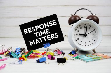 Yanıt süresi kağıt üzerinde metin ve ahşap zemin üzerinde alarm saati içerir