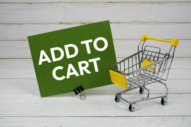 Kağıt karta küçük tramvay alışveriş arabasıyla ahşap arka planda Cart mesajı ekle