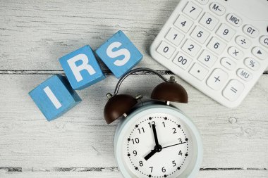 Tahta zemin üzerinde alarm saati ve hesap makinesi olan IRS (Faest Rate Swap) metni