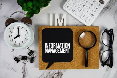 IM - Hesap makinesi, alarm saati ve büyüteçle Bilgi Yönetimi kısaltması, iş konsepti arka planı