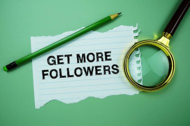 Daha Fazla Takipçi Al metni kağıda yazılsın büyüteç düz olarak yeşil arkaplanda yatsın