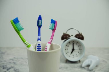 Alarmlı diş fırçası ve mermer arka planda beyaz diş modeli diş hijyeni kavramı