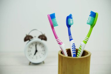Çalar saat diş fırçası ahşap arka planda diş hijyeni kavramı