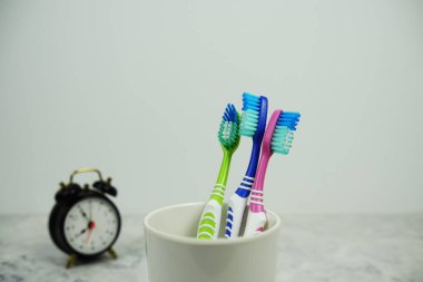 Çalar saat diş fırçası mermer arka planda diş hijyeni kavramı