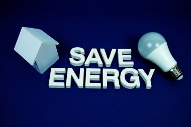Ev modelli enerji alfabesi harflerini ve lacivert arka planda LED ampulleri, tasarruf ve çevre dostu kavramı içeren enerji alfabesini kaydet