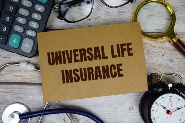Tahta zemin üzerinde hesap makinesi, büyüteç ve alarm saati olan Evrensel Yaşam Sigortası metni