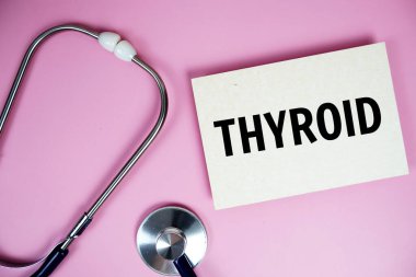 Pembe arka planda steteskoplu tiroid metni, sağlıklı ve sağlıklı olma kavramı