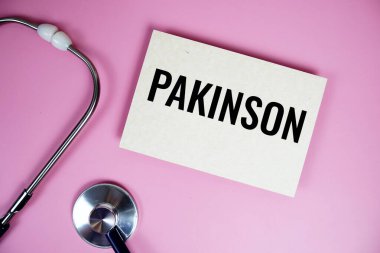 Pembe arka planda steteskoplu Pakinson metni, sağlıklı ve sağlıklı olma kavramı