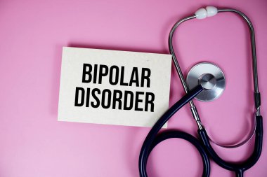 Pembe arkaplan, sağIık ve sağIık kavramı üzerine steteskoplu bipolar bozukluk metni