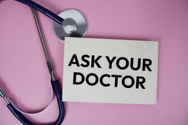 Pembe arkaplan, sağlıklı ve sağlıklılık kavramını steteskop üst görüşlü doktorunuza sorun