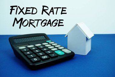 Lacivert arkaplan, ipotek ve gayrimenkul kavramları üzerinde hesap makineli Beyaz Saray modeliyle sabitlenmiş ipotek metni