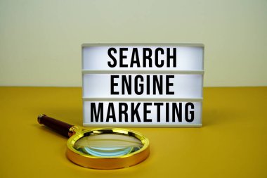 LED ışık kutusu üzerinde sarı zemin üzerinde büyüteç ile Arama Motoru Pazarlama metni